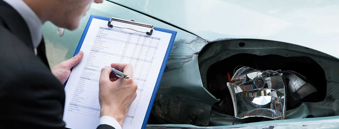 Claims adjuster reviewing damage to a vehicle