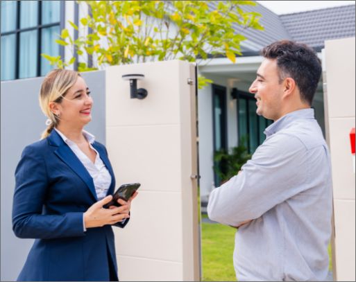 women to talking man outside a house