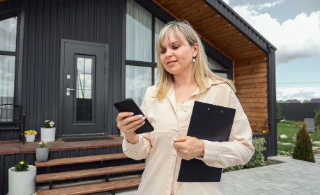 real estate agent in front of house on her phone